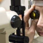 Optometrist performing a diabetic eye exam with a slit lamp on a female patient